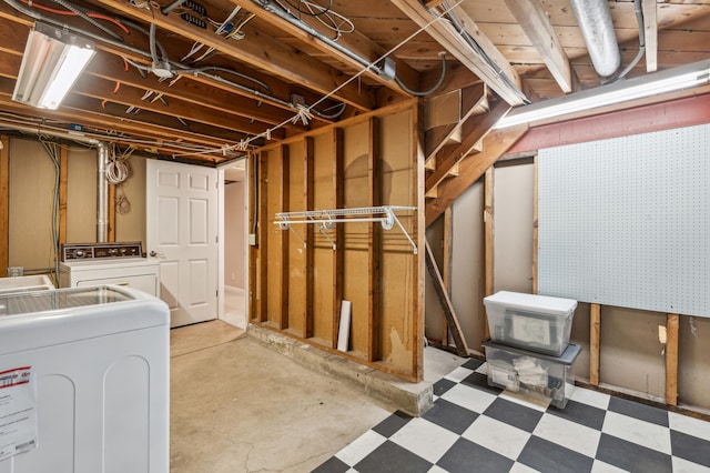 unfinished below grade area featuring washing machine and dryer and light floors