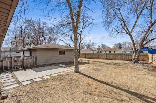 view of yard featuring a patio, a fenced backyard, and a residential view