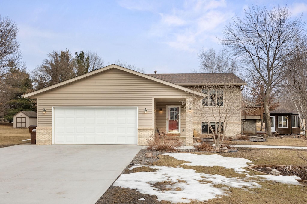 view of front of house featuring an attached garage, brick siding, and driveway