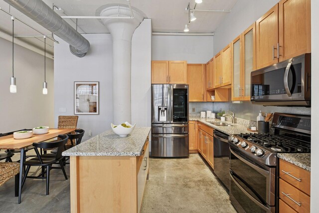 250 Park Ave Unit 606, Minneapolis, MN 55415 - kitchen with stainless steel appliances, a towering ceiling, a center island, light stone counters, and rail lighting