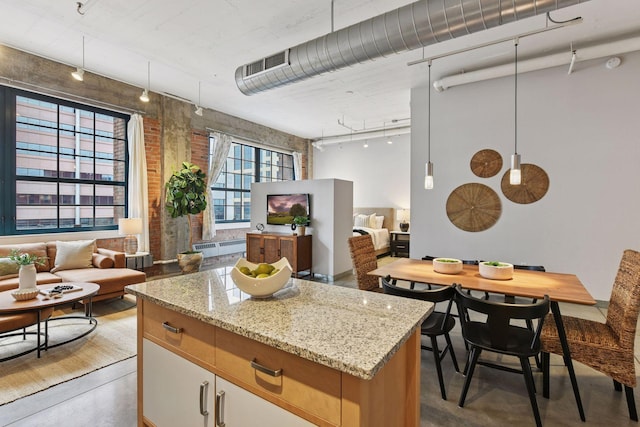 250 Park Ave Unit 606, Minneapolis, MN 55415 - kitchen with finished concrete flooring, rail lighting, open floor plan, light stone countertops, and a center island