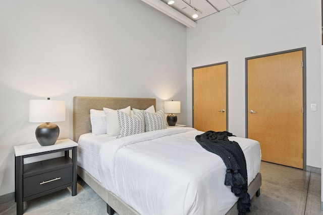 250 Park Ave Unit 606, Minneapolis, MN 55415 - bedroom with finished concrete floors, a high ceiling, and rail lighting