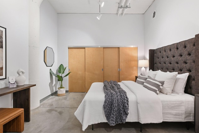 250 Park Ave Unit 606, Minneapolis, MN 55415 - bedroom featuring concrete flooring, a closet, and rail lighting