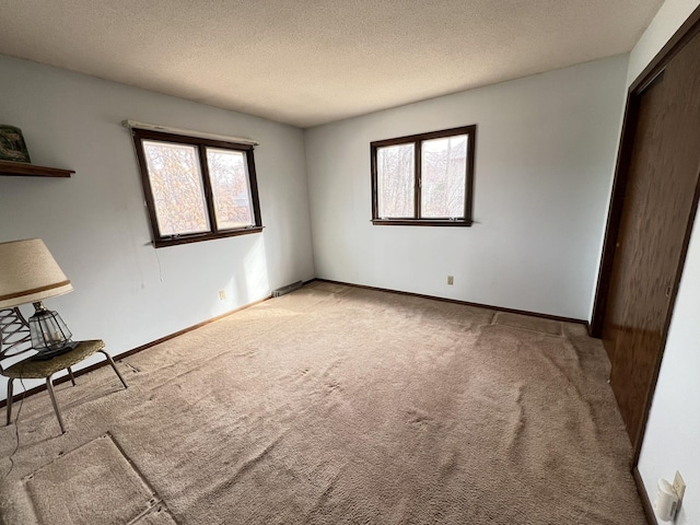 unfurnished bedroom featuring baseboards, carpet floors, and a textured ceiling