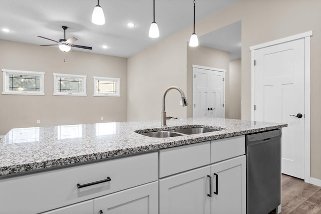 kitchen featuring light wood finished floors, ceiling fan, decorative light fixtures, stainless steel dishwasher, and a sink