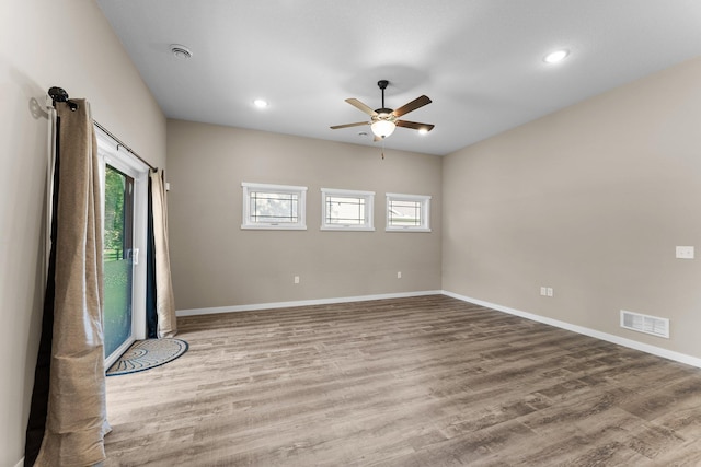 unfurnished room featuring visible vents, baseboards, wood finished floors, and a ceiling fan