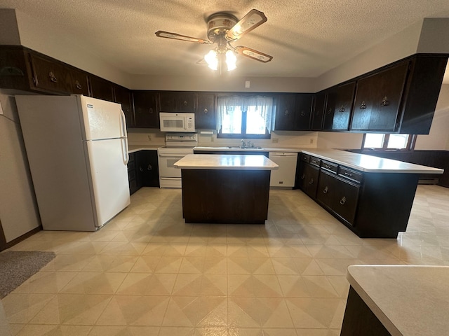 kitchen featuring white appliances, ceiling fan, a sink, light countertops, and a textured ceiling