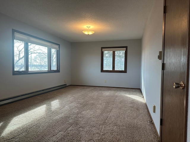 empty room featuring a baseboard heating unit, baseboards, and a textured ceiling