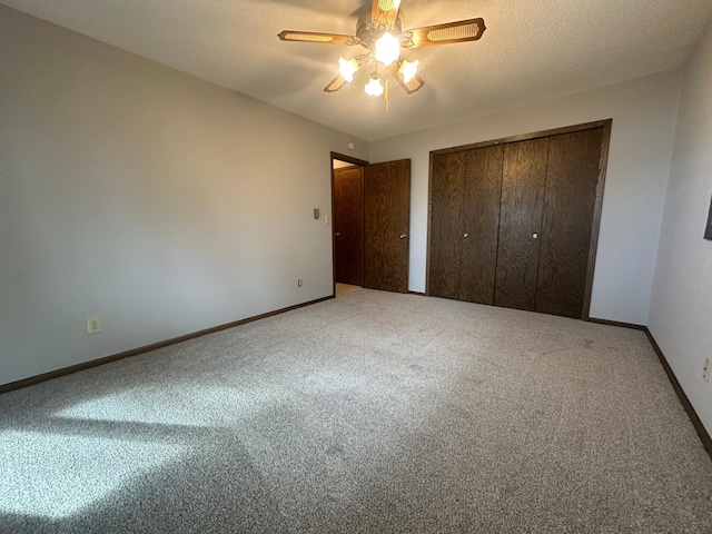 unfurnished bedroom featuring a ceiling fan, baseboards, carpet floors, a closet, and a textured ceiling