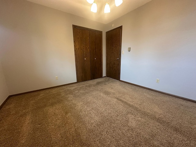 unfurnished bedroom featuring a closet, baseboards, carpet, and a ceiling fan