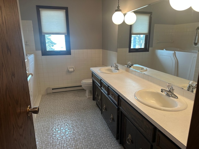 bathroom featuring a sink, tile walls, tile patterned flooring, and a baseboard radiator