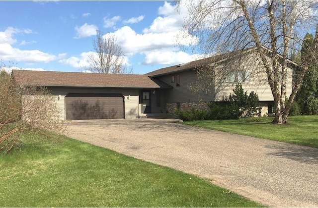 split level home featuring a front yard, a garage, and driveway