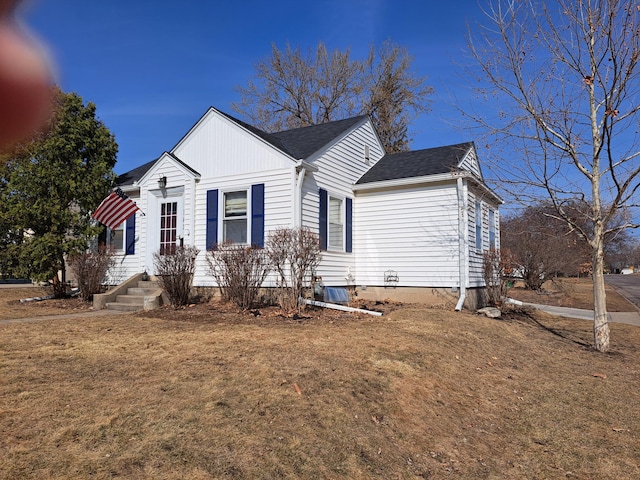 view of home's exterior featuring a lawn and roof with shingles