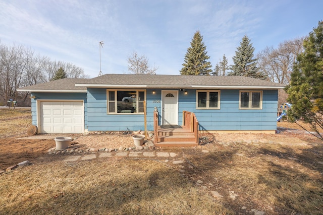 ranch-style home with a garage and a shingled roof