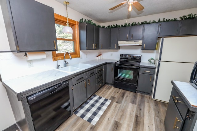 kitchen with ceiling fan, under cabinet range hood, light wood-type flooring, black appliances, and a sink