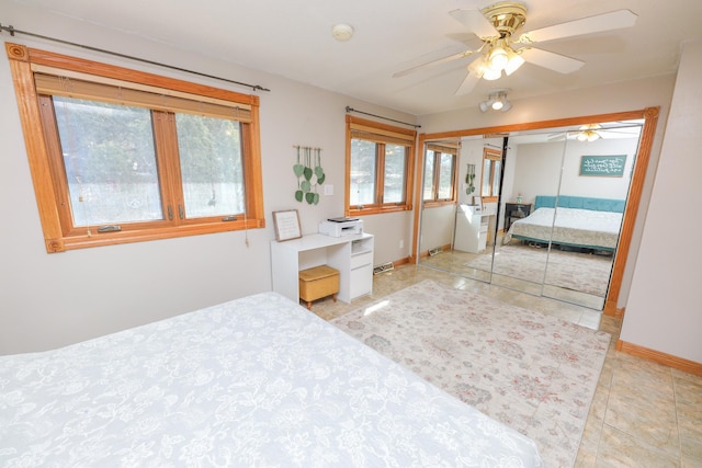 bedroom featuring visible vents, baseboards, light tile patterned floors, a closet, and a ceiling fan