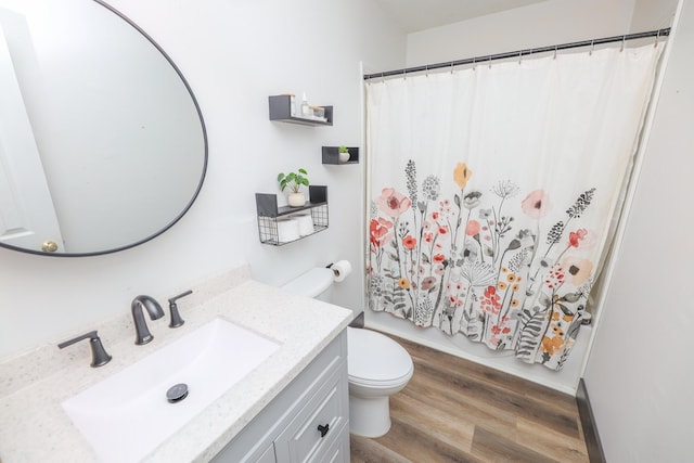 bathroom featuring vanity, curtained shower, toilet, and wood finished floors