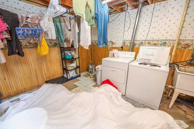 washroom featuring laundry area, wooden walls, and washing machine and dryer