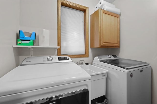 laundry area featuring cabinet space, washer and dryer, and a sink