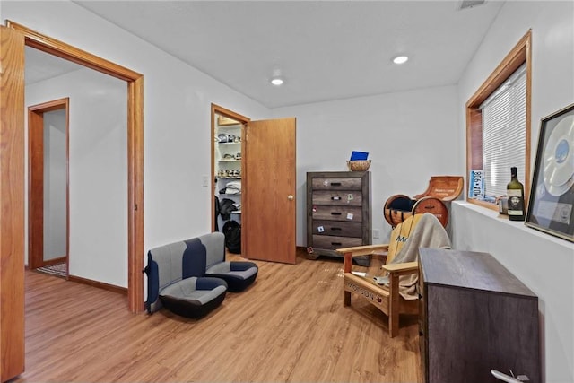 living area featuring recessed lighting, baseboards, and light wood finished floors