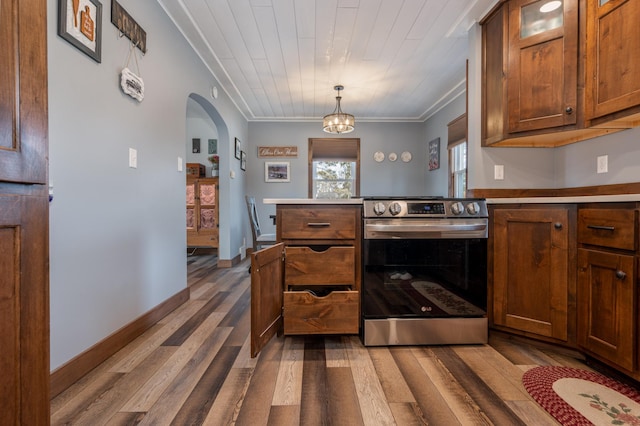 kitchen featuring wood finished floors, arched walkways, stainless steel electric range, crown molding, and a chandelier