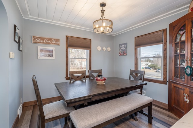 dining area with wood finished floors, baseboards, plenty of natural light, and a chandelier