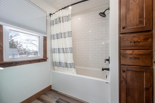 bathroom with shower / bath combination with curtain, wood finished floors, and baseboards