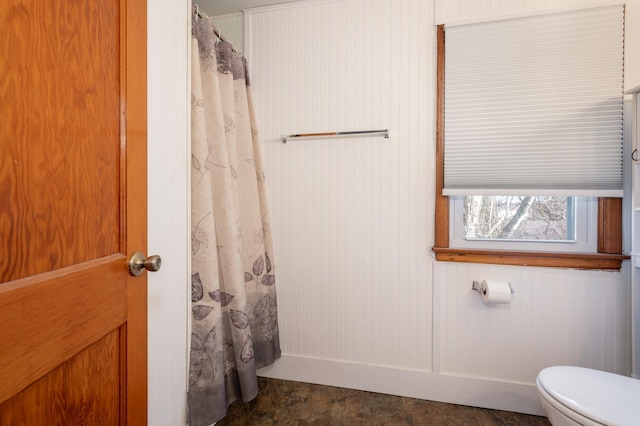 bathroom with a shower with shower curtain and toilet