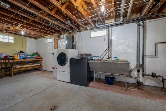 basement featuring washer and dryer, electric panel, and a sink