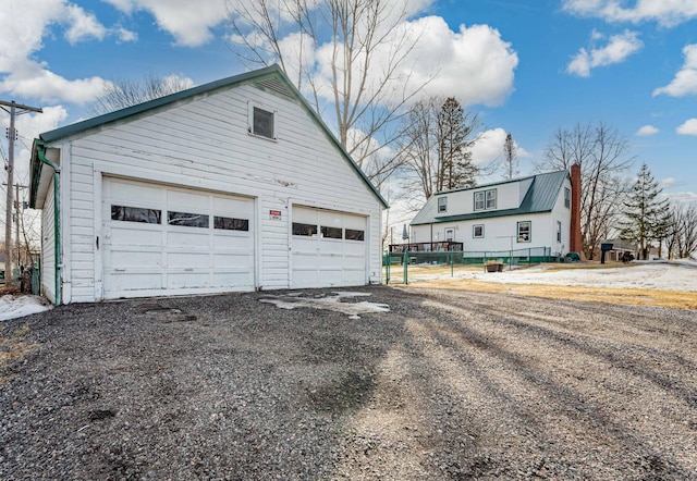 view of side of home with a garage and an outbuilding