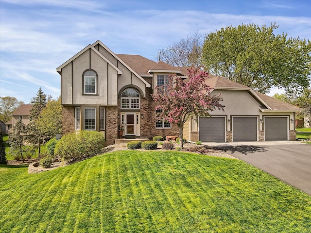 view of front facade featuring stucco siding, driveway, an attached garage, and a front lawn