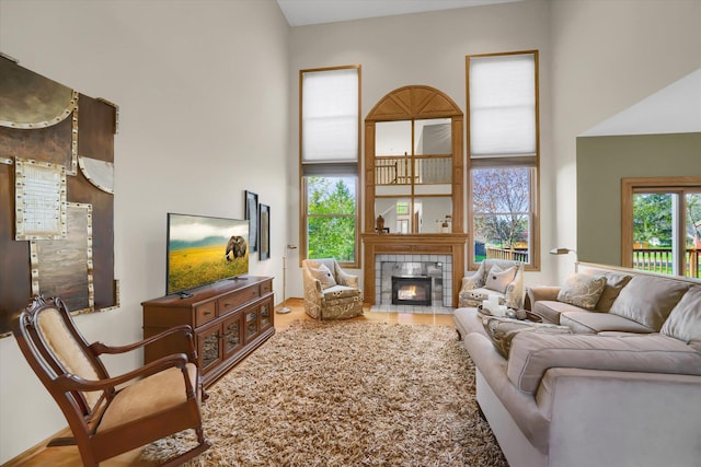 living room with a high ceiling and a tile fireplace