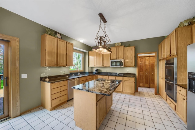 kitchen featuring light tile patterned floors, a sink, appliances with stainless steel finishes, decorative light fixtures, and a center island