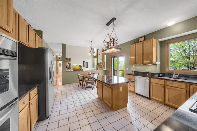 kitchen with a sink, appliances with stainless steel finishes, a wealth of natural light, and light tile patterned floors