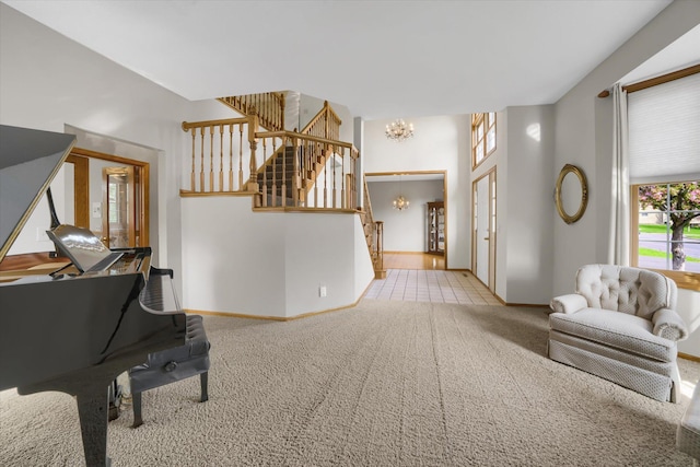 sitting room featuring stairway, carpet, baseboards, and a chandelier