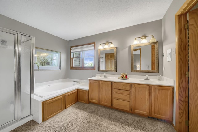 bathroom featuring a sink, a garden tub, a textured ceiling, and a shower stall