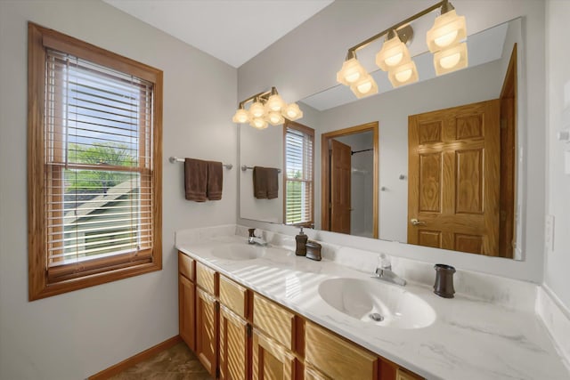 bathroom with double vanity, baseboards, and a sink