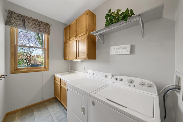 laundry area featuring washer and dryer, a sink, cabinet space, light tile patterned floors, and baseboards