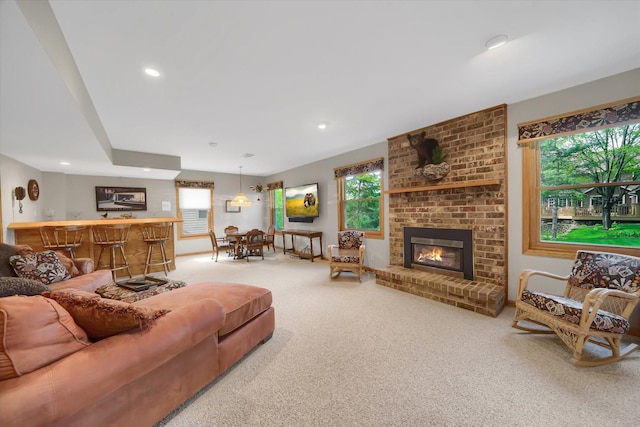 carpeted living room featuring bar area, a fireplace, and recessed lighting