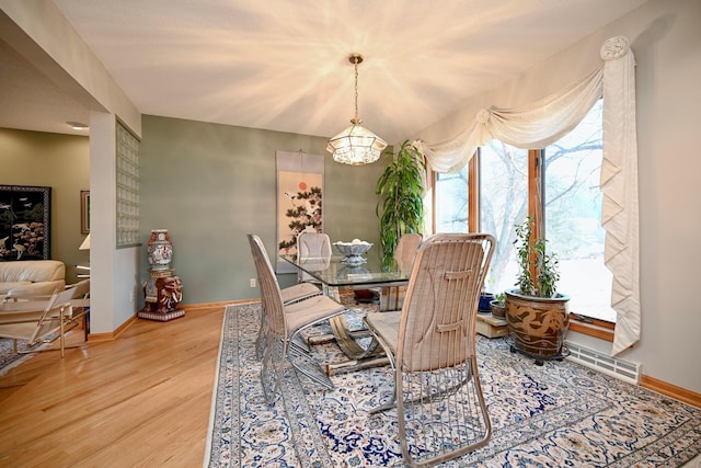 dining room with visible vents, baseboards, a notable chandelier, and wood finished floors