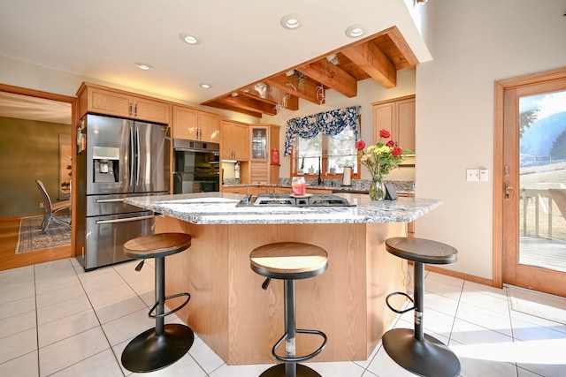 kitchen with a healthy amount of sunlight, a kitchen bar, recessed lighting, appliances with stainless steel finishes, and light tile patterned flooring