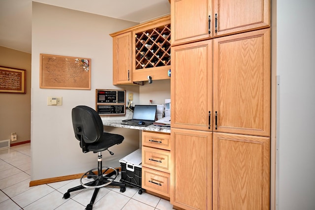 office space featuring light tile patterned floors, built in desk, visible vents, and baseboards