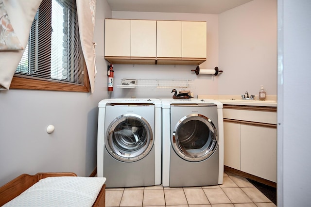 clothes washing area with a sink, cabinet space, independent washer and dryer, and light tile patterned flooring