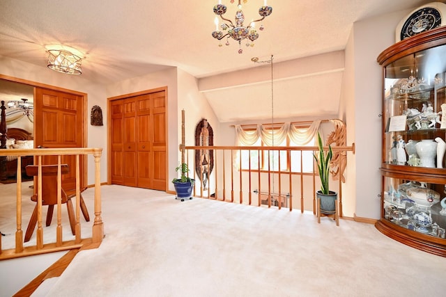 carpeted foyer with a chandelier, baseboards, and lofted ceiling