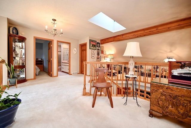 living area with visible vents, baseboards, light carpet, a skylight, and a notable chandelier