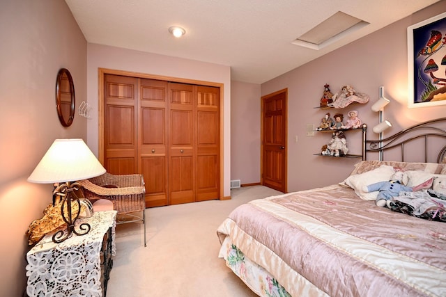 bedroom featuring attic access, visible vents, a closet, and light carpet