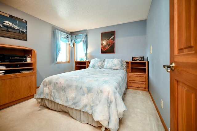 bedroom featuring baseboards, carpet floors, and a textured ceiling