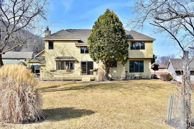 back of property featuring a shingled roof, a wooden deck, a yard, and a chimney