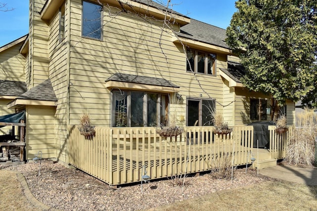 rear view of house with a shingled roof