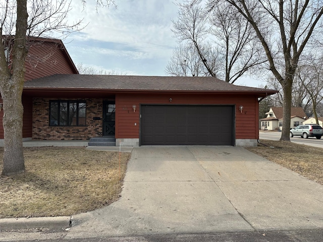 view of front of house with concrete driveway, an attached garage, brick siding, and a shingled roof